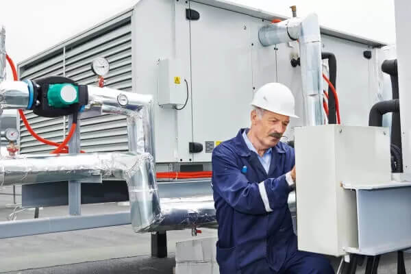 Engenheiro mecânico vistoriando sistema de climatização de estabelecimento comercial